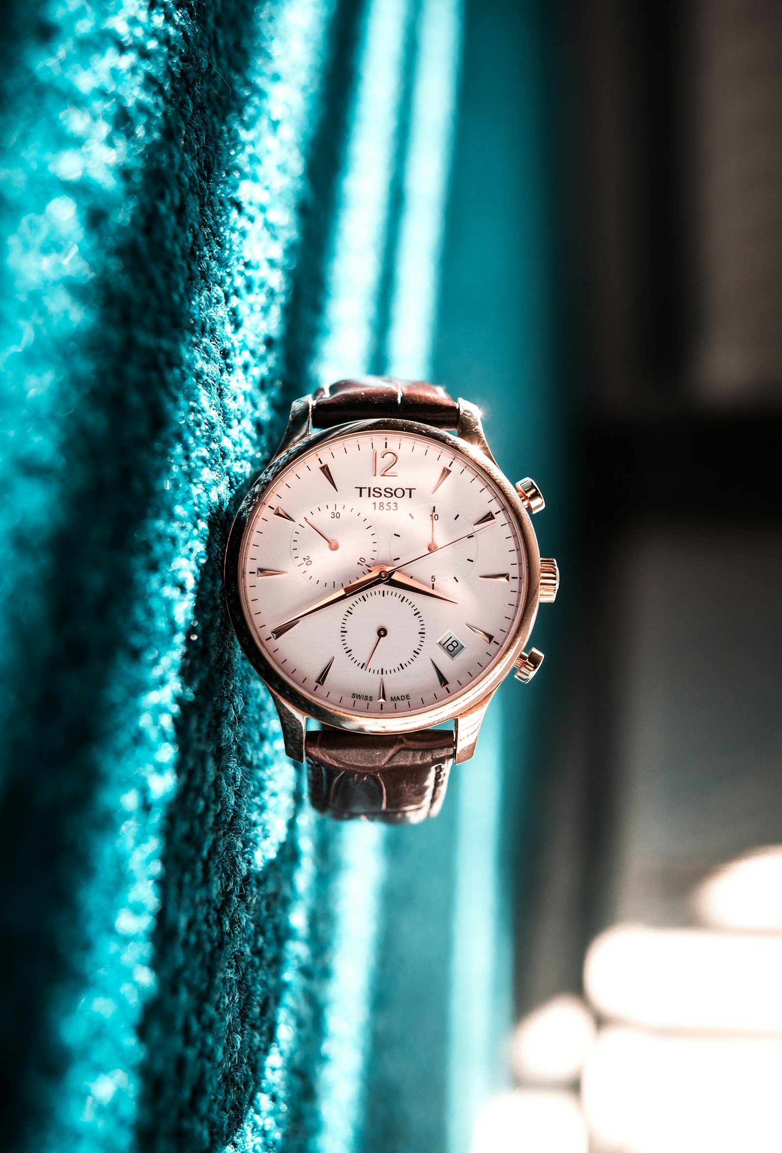 Rose gold watch on draped fabric